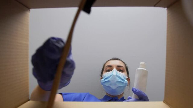 delivery, shipping and pandemic concept - woman in protective medical mask and gloves packing parcel box with beauty and dental care products