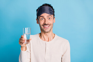 Photo portrait of excited guy holding water glass in one hand isolated on vivid blue colored background