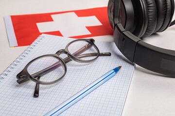 Learning foreign languages in Switzerland with audio recordings and headphones. Notepad, glasses,...