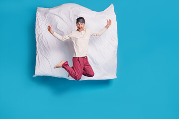 Full length photo portrait of excited guy jumping up with blanket behind isolated on vivid blue...