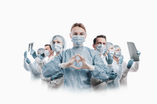 medical workers heroes. a nurse in the foreground in a mask and uniform holds her hands in the shape of a heart. go to a lot of medical professionals.