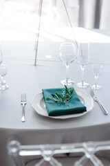 glass glasses and a white plate with a napkin on the table