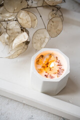Home decoration with burning aromatic candle, white interior decor