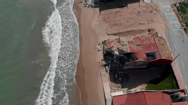 Aerial view damaged beach houses and surf of Mediterranean Sea. The wind and waves is washed away the beach houses on the Babilonia beach. Guardamar del Segura. Province of Alicante. Spain  