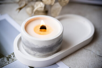 Fototapeta na wymiar Home decoration with burning aromatic candle, white interior decor