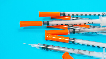 Insulin vial and syringe on blue background. Health care, doctor, clinic or hospital, medical concept. World diabetes day. Ready for vaccine injection. Pain treatment, illegal use, vaccination
