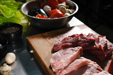 Raw fresh meat Ribeye steak entrecote pork and beef and seasonings on wooden cutting board.