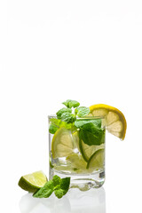 Citrus lemonade with ice in a glass decorated with lemon, lime and mint slices and on a white background. Fresh summer drink. Detox. Healthy food rich in vitamins and antioxidants. Copy space