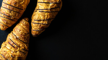 Croissant texture. French breakfast croissants, fresh pastry bread with chocolate in bakery on dark stone background. Bread bakery products cafe concept, flat lay.