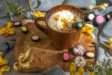 Obraz na płótnie Canvas wooden coffee cup, dry yellow flowers, licorice candy,. top view, layout,