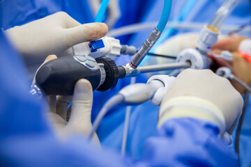Doctor in blue sterile surgical gown suite doing minimal invasive surgery with camera and...