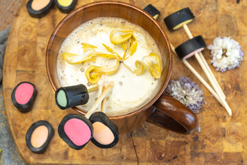 wooden coffee cup, dry yellow flowers, licorice candy,.  top view, layout,