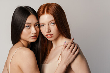 Multiracial two women posing and looking at camera