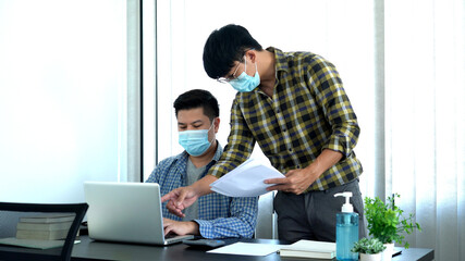Fototapeta premium Coronavirus Office workers with mask for corona virus pandemic in the world working in office after lockdown but business must be continuous.
