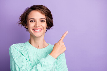 Photo of young happy positive smiling cheerful girl point finger copyspace advertisement isolated on violet color background - obrazy, fototapety, plakaty