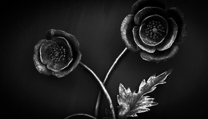 Close-up detail of beautiful vintage forged metal big flower decorating iron gray fence