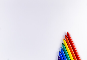 Top shot of colorful sketch pens on a white background with copy space in childhood concept.