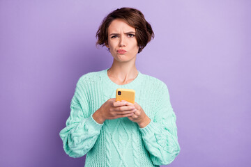 Photo of young woman unhappy sad upset chat type sms cellphone isolated over violet color background