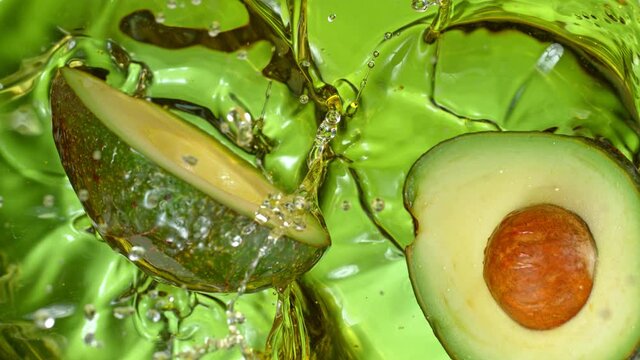 Super Slow Motion Shot of Fresh Avocado Falling and Splashing into Oil at 1000 fps.