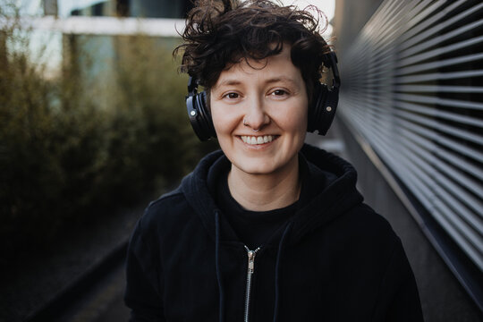  Fr&ouml;hlicher junger Mensch h&ouml;rt Musik mit Kopfh&ouml;rern 