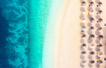 Aerial view on beach and umbrellas. Vacation and adventure. Top view from drone at beach and blue sea. Croatia. Travel and vacation image