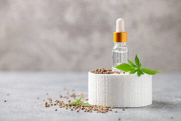 Cbd cannabis cosmetic oil or serum and marijuana leaves and seeds on podium background . Medical...