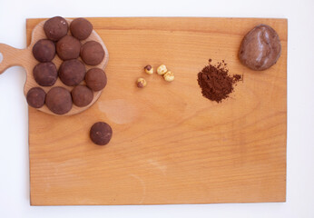 Рand made chocolate truffles dusted with cocoa powder on a wooden board.