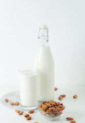 A glass with almond milk and the bowl with almonds