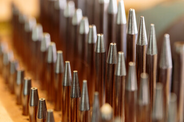 Horizontal closeup view of set of high quality watchmaker staking punches of various diameters for watchmaking and restoration, metal precision instruments. Fine master watchmaker metal pin kit.