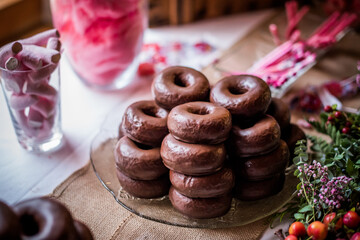 a lot of chocolate donuts on a plate