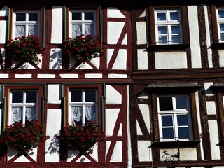 Fachwerkfassade in weiss-braun-rot mit Fenster und Blumen