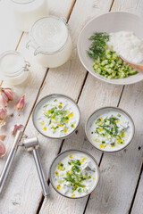 Traditional summer cold soup of homemade yogurt, cucumbers and fresh herbs on a table