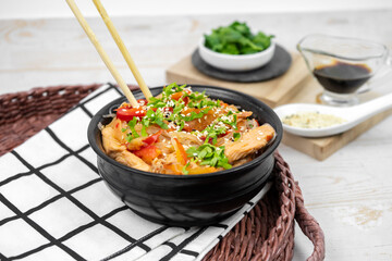 Asian salad with rice noodles, vegetables, mushrooms, chicken and soy sauce. Funchose with white transparent noodles in black plate