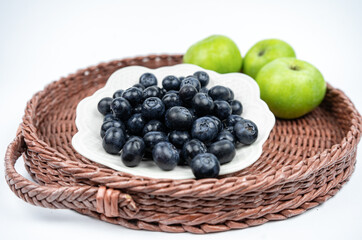 Summer harvest of fresh ripe blueberries and green apples in a basket