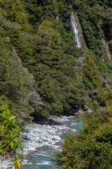 Obraz premium Rocky terrain and a waterfall at Thunder Creek in New Zealand