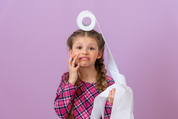 A little girl is terrified of a roll of toilet paper on her head.