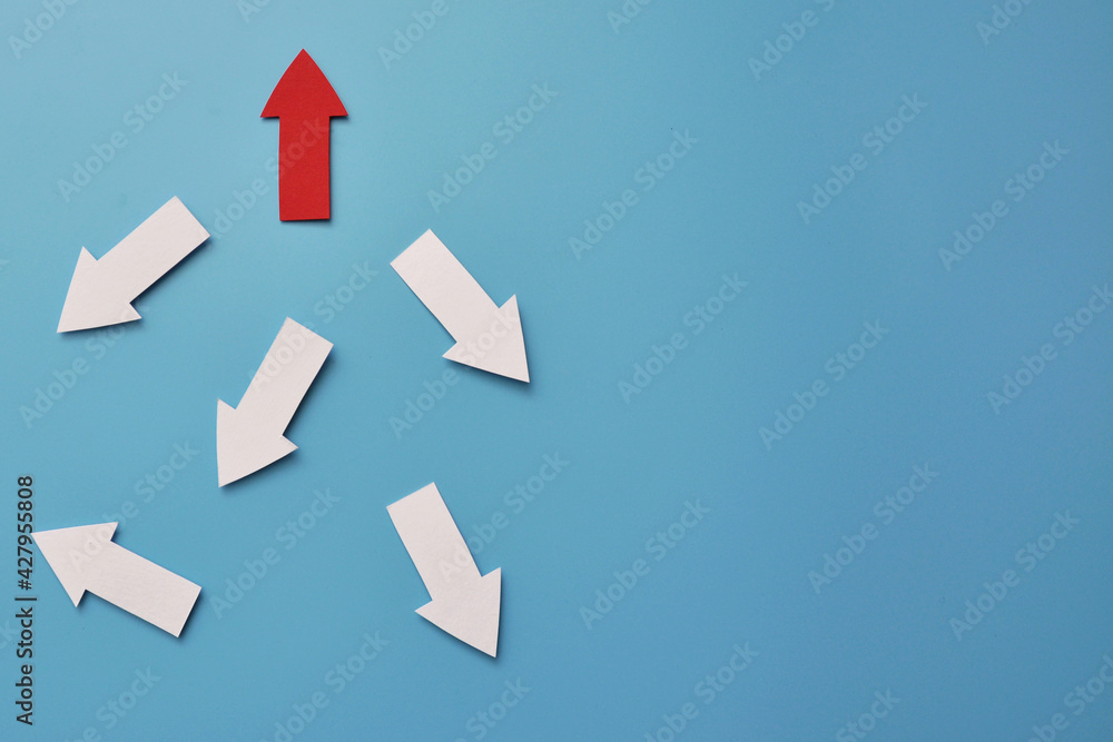 Poster there are many white arrows pointing in different directions and one red arrow pointing up. a symbol