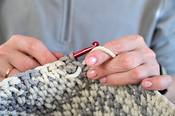 A close view of female hands being crocheted