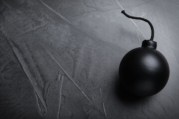 Sphere shaped bomb with burning fuse on black background, top view. Space for text