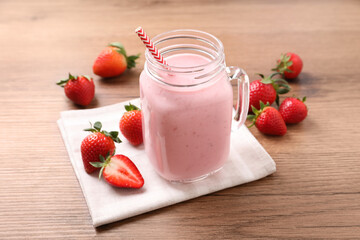 Delicious strawberry drink in mason jar on wooden table