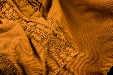 clothing items stonewashed cotton fabric texture with seams, clasps, buttons and rivets, macro