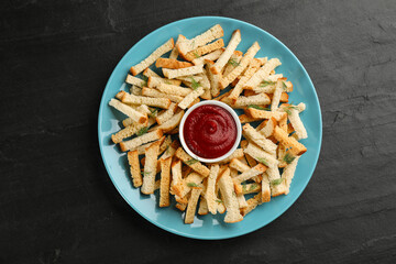 Delicious hard chucks with ketchup on black table, top view