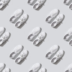 Seamless pattern of white female new gumshoes on grey background. Sport and casual outfit.