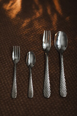 silver stainless cutlery on a dark fabric background
