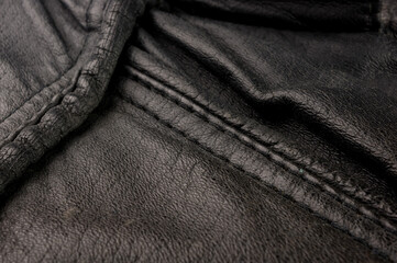 Old vintage genuine soft black leather texture background, top layer with pores and scratches, macro, close-up