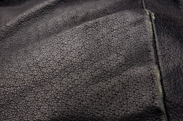 Old vintage genuine soft black leather texture background, top layer with pores and scratches,...