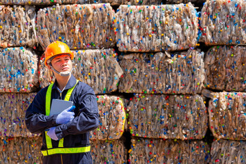 Engineer recycle and Environment concept. Engineers standing in recycling center. Male foreman wearing protective equipments and holding tablet.