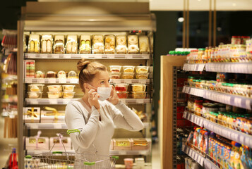 Woman reading product information.Supermarket shopping, face mask