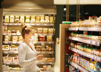 Woman reading product information.Supermarket shopping, face mask