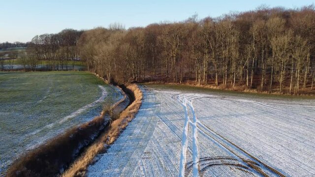 Drohnenaufnahme von einem Wald in Norddeutschland im Winter mit ein wenig Schnee.